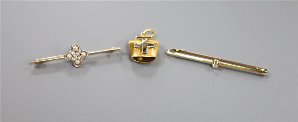 A 750 yellow metal cow bell charm, a 15ct seed pearl and diamond chip set bar brooch and one other bar brooch.